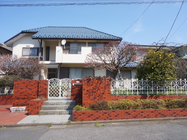外観。赤いレンガと青の屋根が可愛い！庭の木々も春めいてきました。