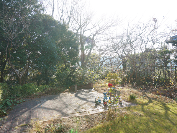 敷地南側にある、急斜面と谷を見下ろす芝生の庭。西側方向には海も見えます。