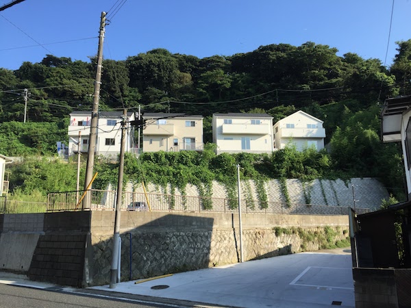 新築4兄弟、緑にうずまるようにして建ってます。後ろは披露山。