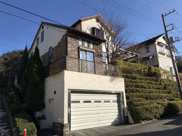 地中海を思わせるオレンジ瓦の屋根。青い空と濃い緑に溶け込む素敵な外観です。