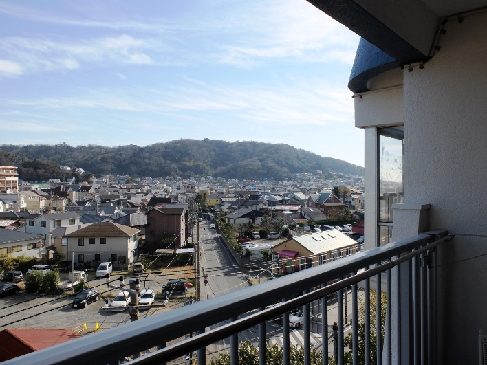 ブルーの屋根の向こうには、海が見える。道の向かう先には空と山並みの境界。