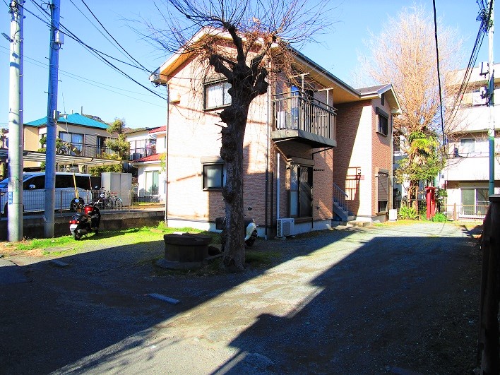 細長い土地にアパートが建っています。
