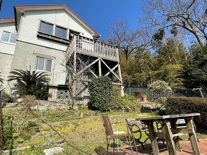 山に囲まれた三角屋根の平屋のお家。