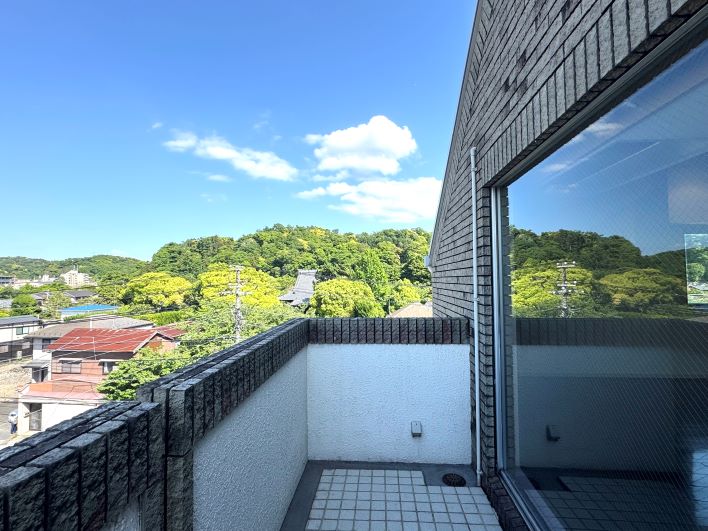 たくさんの緑と宝戒寺本堂の頭がちょこっと見えるバルコニー